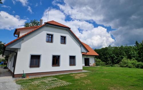 a white house with an orange roof at Ubytování U Bohouše in Horní Radouň
