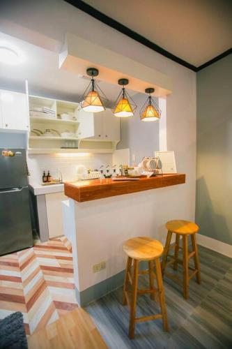 a kitchen with two stools next to a counter at Kozy Haven - Wifi + AC in Butuan