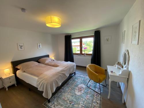 a bedroom with a bed and a desk and a window at 4 Zimmer Wohnung, 6 Bed, Küche, Waschmaschine, Wlan, Garden, free Parking in Tacherting