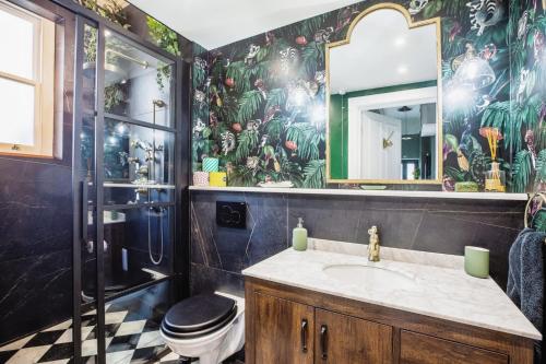 Charming 1 Bed London Flat في لندن: حمام مع حوض ومرحاض ومرآة