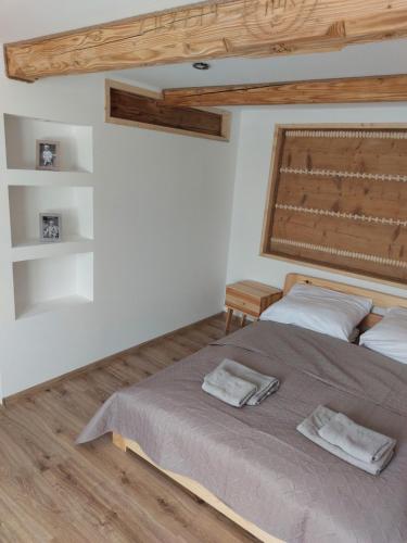 1 dormitorio con 1 cama con 2 toallas en Agroturystyka ,Jarzębina', en Harkabuz