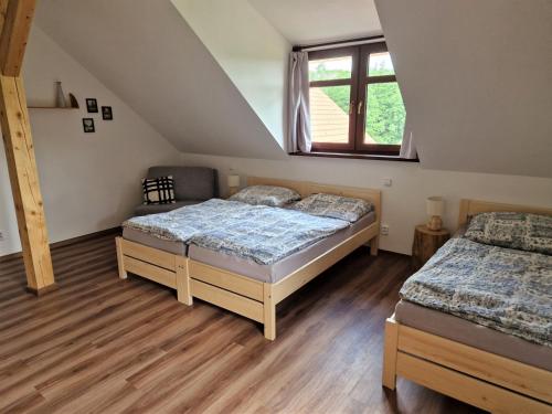 a bedroom with two beds and a window at Ubytování U Bohouše in Horní Radouň