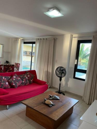 a living room with a red couch and a table at Paribahia in Praia do Forte