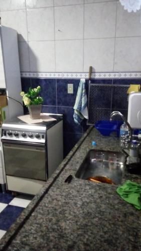 a kitchen with a sink and a stove at Casa Mongagua in Mongaguá