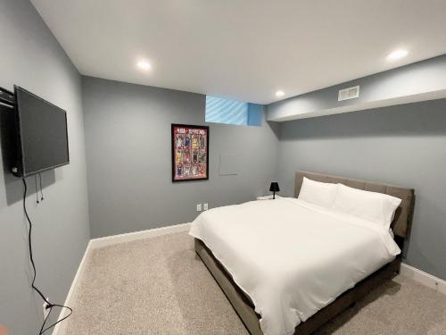 a bedroom with a bed and a flat screen tv at The Blue House! Modern+ Rooftop deck+ Parking in Baltimore