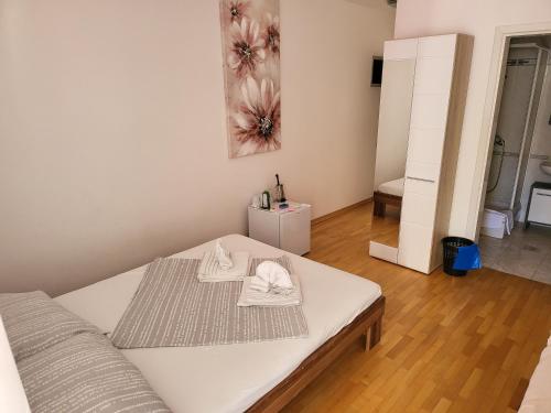 a white bed with two towels on it in a room at Soba L&L Povljana in Povljana