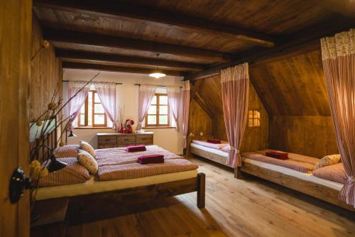 a bedroom with two beds in a room with wooden walls at Selské stavení Melchior Häusler in Šonov