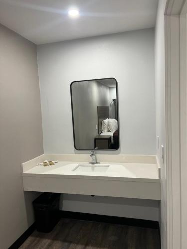 a bathroom with a sink and a mirror at Vance Motel in Lynwood