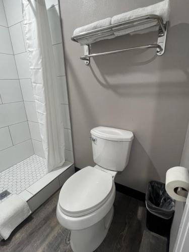 a white bathroom with a toilet and a shower at Vance Motel in Lynwood