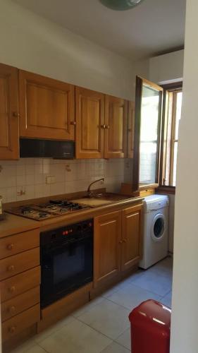 a kitchen with wooden cabinets and a stove and a dishwasher at Isola del Giglio casa Nico e casa Camilla Monticello Giglio Porto in Isola del Giglio