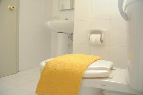 - Baño con aseo y toalla amarilla en Shamrock Apartments, en St Paul's Bay