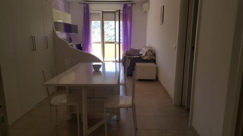 a table and chairs in a room with purple walls at Isola del Giglio casa Nico e casa Camilla Monticello Giglio Porto in Isola del Giglio