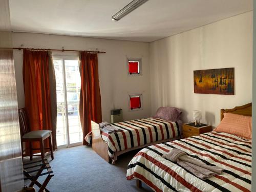 a bedroom with two beds and a sliding glass door at KAD Alojamiento in Mendoza