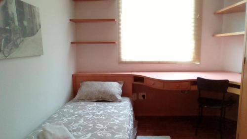 Habitación pequeña con cama y ventana en Aconchego bem localizado, en Varginha
