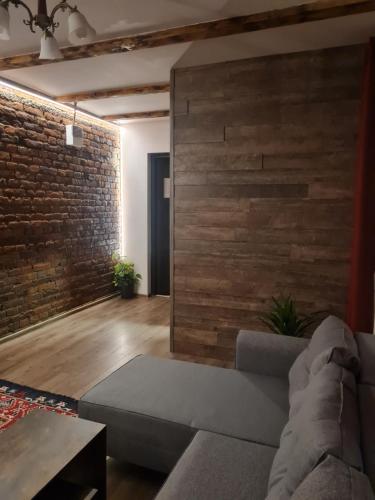 a living room with a couch and a brick wall at Conacul Ancuței in Brad