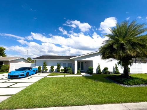 a blue car parked in front of a house at House Of Art - Luxury Villa with Pool & Jacuzzi! in Tamiami