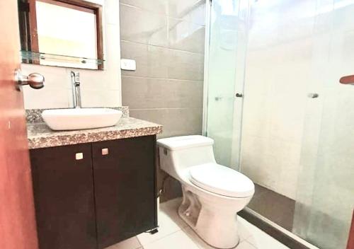 uma casa de banho com um WC, um lavatório e um chuveiro em SUITE REPUBLICA DEL SALVADOR LA CAROLINA em Quito