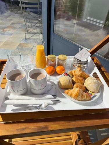 a tray of breakfast foods and coffee on a table at Chambre privatif spa in Lestrem