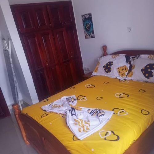 a bedroom with a yellow bed with towels on it at RÉSIDENCE 2K Studio Meublé-Chapelle Symbock-Gardien-WIFI-Location Véhicule in Yaoundé