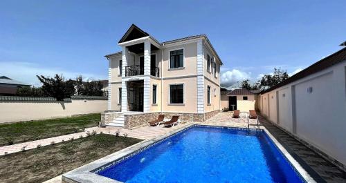 a house with a swimming pool in front of a house at Qafqaz Manor Napoli in Gabala