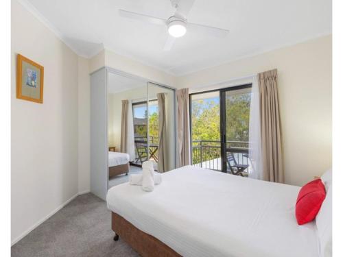een slaapkamer met een groot wit bed en een balkon bij Beachfront Apartments in Port Macquarie