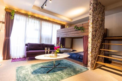 ein Wohnzimmer mit einem Tisch und einem Bett in der Unterkunft Hotel Tokyo Hub - Vacation STAY 27688v in Tokio