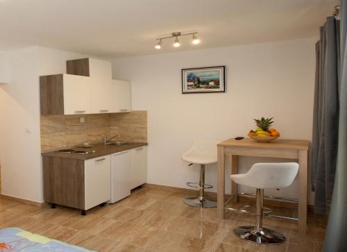 uma cozinha com um lavatório e uma mesa com cadeiras em Central Luxury Rooms Izidor em Split