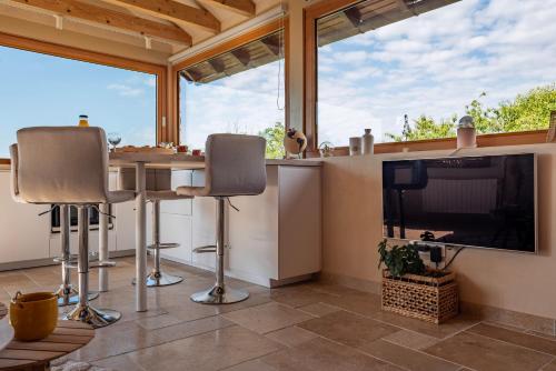 a kitchen with a table and chairs and a large tv at Le Grand Nichoir de la Colline - Parking - Wifi in Mutzig