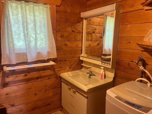 bagno con lavandino, servizi igienici e finestra di Log house Hata - Vacation STAY 29001v a Shima