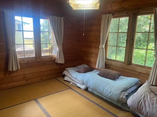 志摩市にあるLog house Hata - Vacation STAY 29001vのログキャビン内のベッドルーム1室(ベッド2台付)