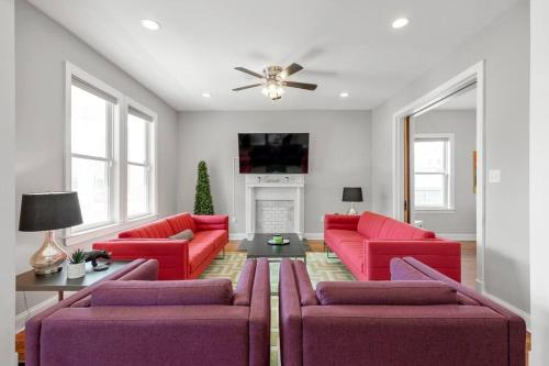 a living room with red furniture and a ceiling fan at Spacious, Vibrant Home 'n Central Richmond, VA! in Richmond