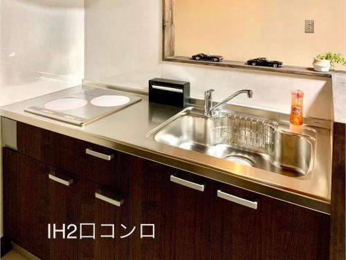 eine Küchentheke mit einem Waschbecken und einem Spiegel in der Unterkunft Guest House Garage IMAZU - Vacation STAY 15208 in Takashima