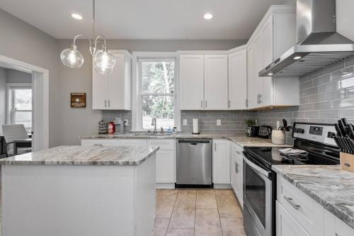 a kitchen with white cabinets and a counter top at Spacious, Vibrant Home 'n Central Richmond, VA! in Richmond