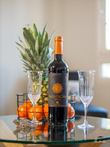 a bottle of wine sitting on a table with two glasses at CASA DE FLAMENCO in Orihuela Costa