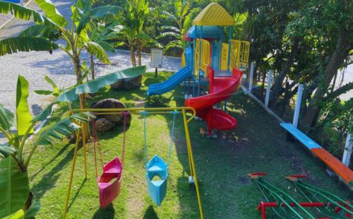 un parque infantil con tobogán y equipo de juegos en Pousada Jovimar, en Aparecida