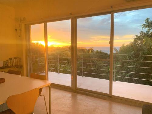 Zimmer mit einem großen Fenster und Blick auf den Sonnenuntergang in der Unterkunft Blue cave Blue in Green - Vacation STAY 31673v in Fukai