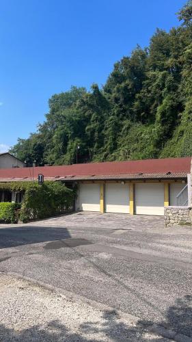 a building with two garage doors and a red roof at CASA BEDIN in Zovencedo