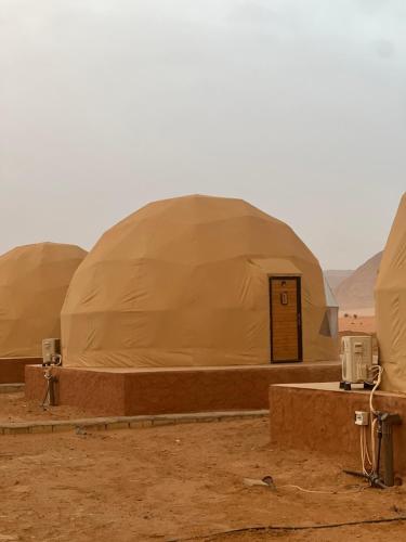 a group of three domes in the desert at Scoop Rum in Wadi Rum