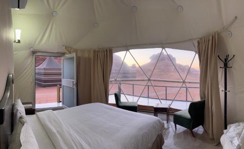 a bedroom with a bed and a large window at Scoop Rum in Wadi Rum