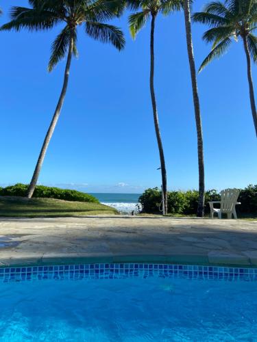 una piscina con palmeras y el océano en 3BR Seaside penthouse - Beach front, en Cabarete