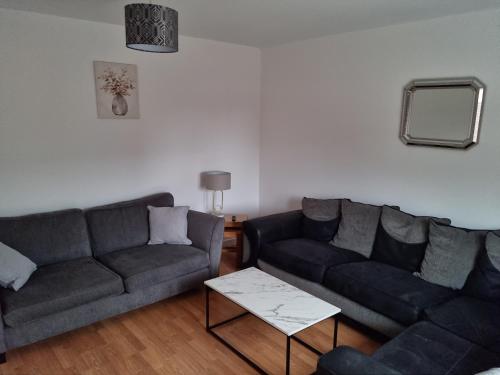 uma sala de estar com dois sofás e uma mesa em 5 bedroom house - Cheshire Oaks em Ellesmere Port