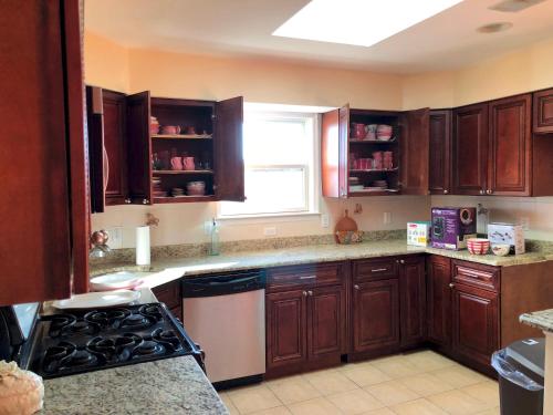 a kitchen with wooden cabinets and a window at Business & Family Friendly Balcony Jacuzzi Free Park in Jersey City