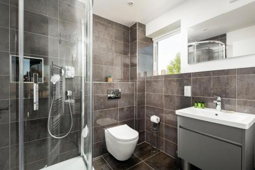 une salle de bain avec une douche, des toilettes et un lavabo dans l'établissement Lakeside property with spa on a nature reserve Butterfly Sound CW10, à Somerford Keynes
