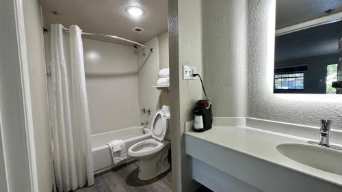 y baño con aseo y lavamanos. en Days Inn by Wyndham San Diego Vista, en Vista