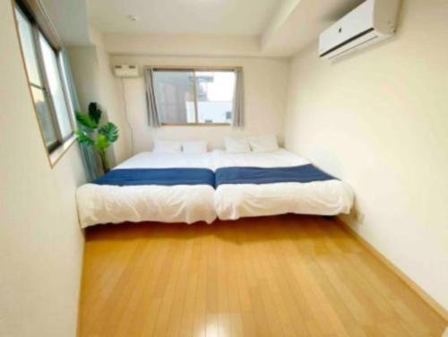 a bedroom with a large bed in a small room at SunStay Fudomae 1 - Vacation STAY 35591v in Tokyo