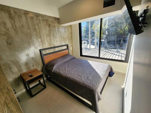 a small bedroom with a bed and a window at Ihost Chapultepec @Serra in Guadalajara
