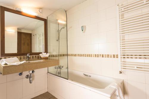 a bathroom with a tub, sink and mirror at Magic Pas in Pas de la Casa
