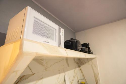 a microwave oven sitting on top of a shelf at Apartamento Quepoa in Quepos