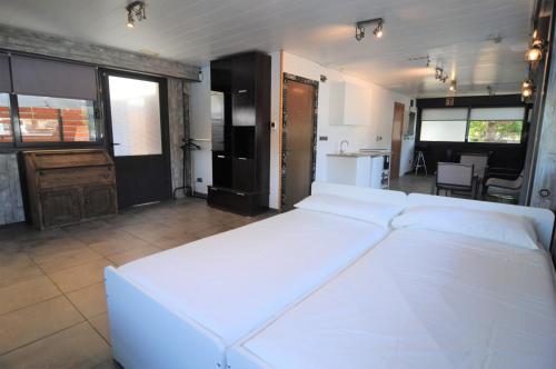 a large white bed in a room with a kitchen at Casa Bohème in Santa Susanna