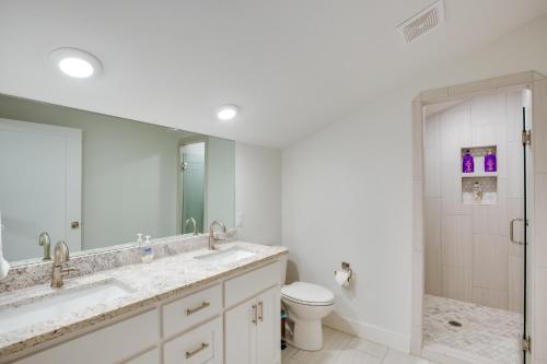 a bathroom with two sinks and a toilet and a mirror at On Cedar Creek Reservoir Malakoff Home with Pool! in Malakoff